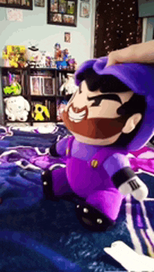 a person is petting a purple mario plush toy