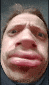 a close up of a man making a funny face with his mouth open .