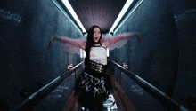 a woman in a black and white outfit is standing in a dark tunnel