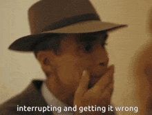 a man wearing a hat is covering his mouth with his hand and the words " interrupting and getting it wrong " are below him