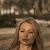 a close up of a woman 's face with long blonde hair .