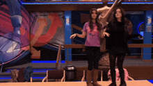two girls are dancing in front of a sign that says ' eee '