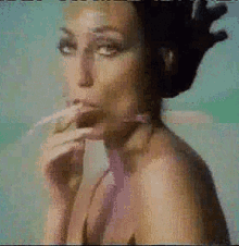 a woman in a bikini smoking a cigarette in a pixelated image