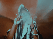 a person smoking a cigarette with a hood on