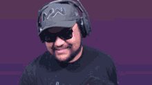 a man wearing headphones and a hat that has the letter m on it