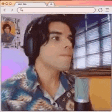 a man wearing headphones is sitting in front of a microphone in a computer screen .