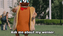 a person in a hot dog costume says " ask me about my weiner "