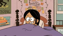 a cartoon of a girl laying in bed with a sign that says familia on it