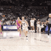 a basketball game is being played in front of a johnson bank sign