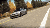 a silver sports car is driving down a road