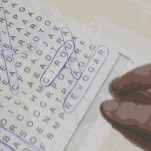 a person 's hand is holding a piece of paper with a crossword puzzle on it