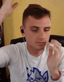 a man wearing ear buds and a white shirt with a fox on it