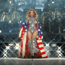 a woman in a bodysuit and american flag coat walking on a stage