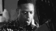 a black and white photo of a woman touching a man 's forehead .