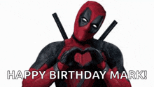 deadpool is making a heart shape with his hands and saying `` happy birthday mark '' .