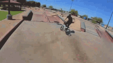 a man riding a bike on a railing in a skate park
