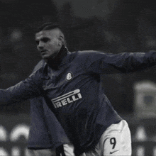 a soccer player is running on a field with a banner that says sangemini in the background