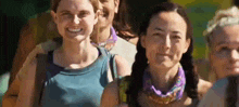 a group of women are standing in a line and smiling .