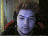 a man wearing headphones looks at the camera in a blurry photo