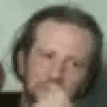 a close up of a man 's face with his hand on his mouth .