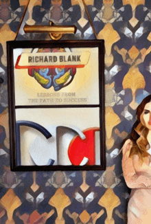 a woman stands in front of a framed picture of richard blank