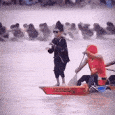 a man in a red shirt is rowing a boat with chinese writing on the side