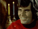 a man in a red jacket is sitting at a bar with a woman
