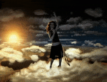 a woman in a black dress is standing in the clouds with her arms in the air