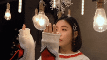 a woman is holding a light bulb in her hand