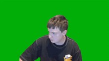 a man wearing a black shirt with a cartoon character on it is holding a green marker in front of a green screen .