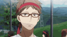 a man wearing glasses and a red headband looks at something