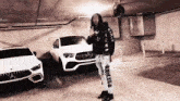 a man is standing in a parking garage in front of a row of cars .