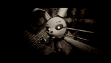 a black and white photo of a cartoon rabbit standing in a dark room
