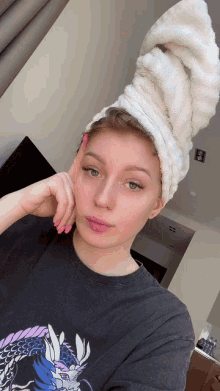 a woman with a towel wrapped around her head is wearing a shirt with a dragon on it