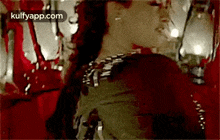 a woman in a red dress is standing in front of a mirror in a dark room .