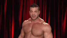 a shirtless man is standing in front of a red curtain and says " who betta "