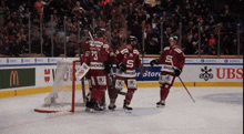 a group of hockey players celebrate a goal sponsored by skoda