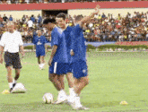 a group of men are playing soccer on a field in front of a crowd .