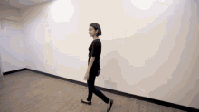 a woman is walking down a hallway in a room .