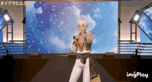 a video of a man singing in front of a large screen that says imgplay on the bottom