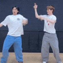 two men are dancing with one wearing a shirt that says a on it
