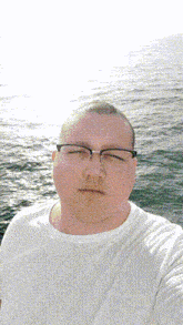 a man wearing glasses and a white shirt takes a selfie