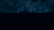 a crowd of people standing in the dark with a red light in the middle