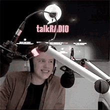 a man wearing headphones is sitting in front of a microphone in front of a talkradio sign