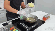 a man is cooking food in a frying pan on a stove top with made in animatica written on the bottom of the screen