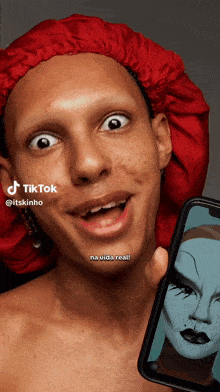 a man wearing a red hat is holding a cell phone with a tiktok watermark