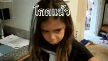 a girl with long hair is making a funny face in a room with a sign in a foreign language