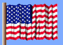 a red white and blue american flag is waving in the wind