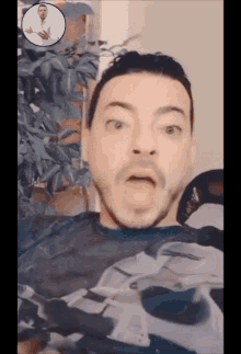 a man with a surprised look on his face is wearing a shirt with a picture of a shark on it