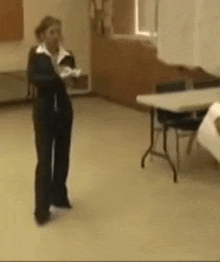 a woman is standing in a room next to a table .